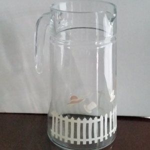 Vintage glass pitcher with white picket fence and hats in the breeze EUC
